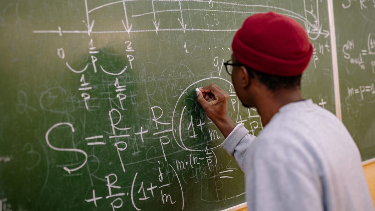 physics student working a problem on a chalkboard