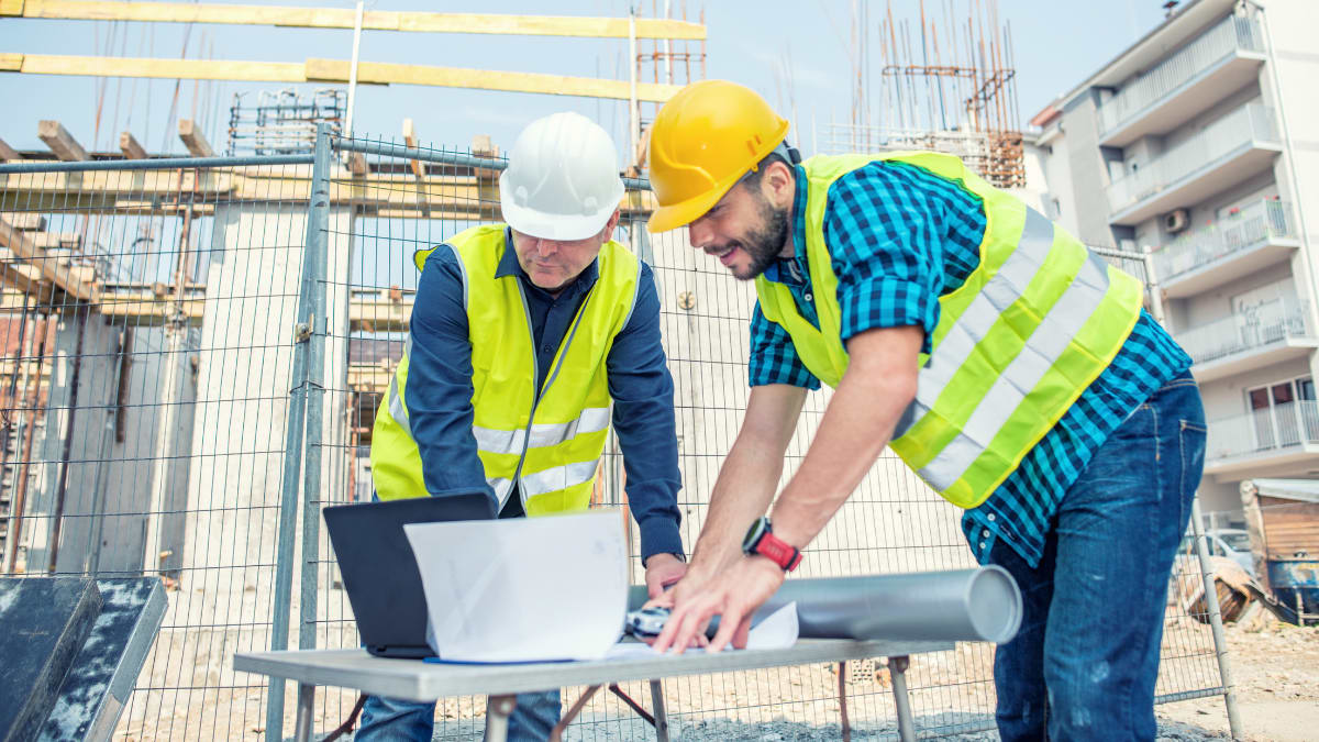 construction manager shows building plans to his crew