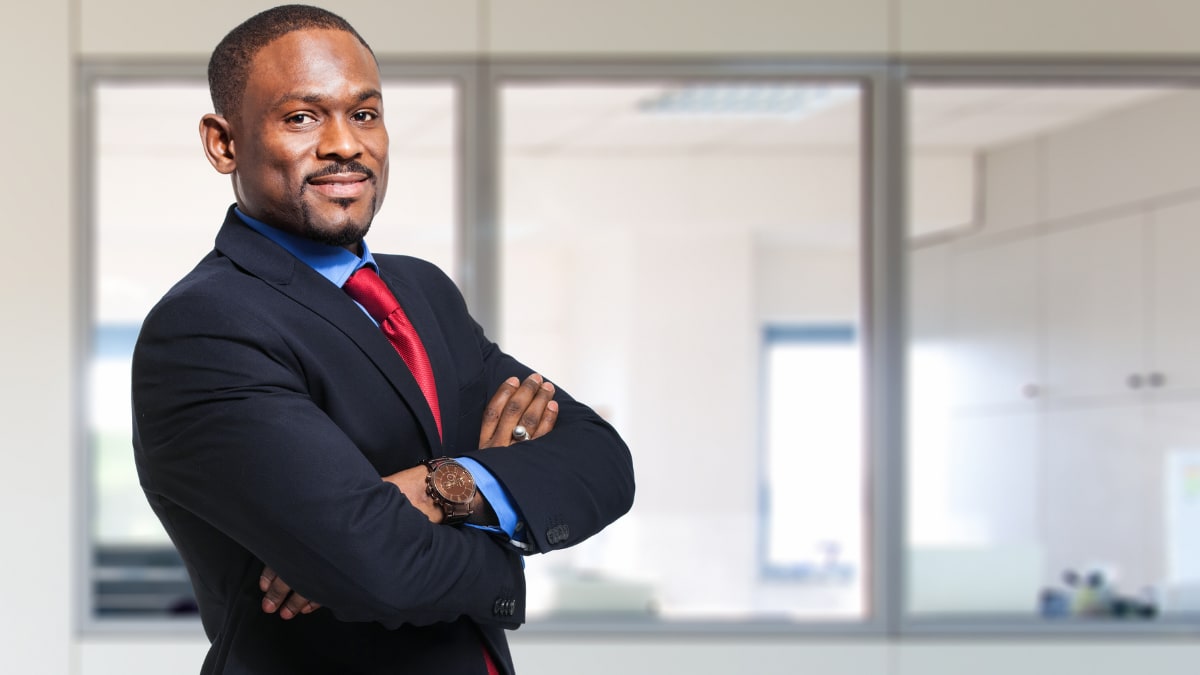 online MBA graduate standing in an office