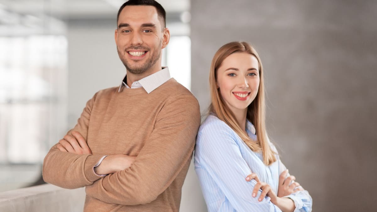 two business professionals standing back to back in an office