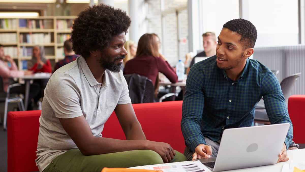 two online college students working in a library