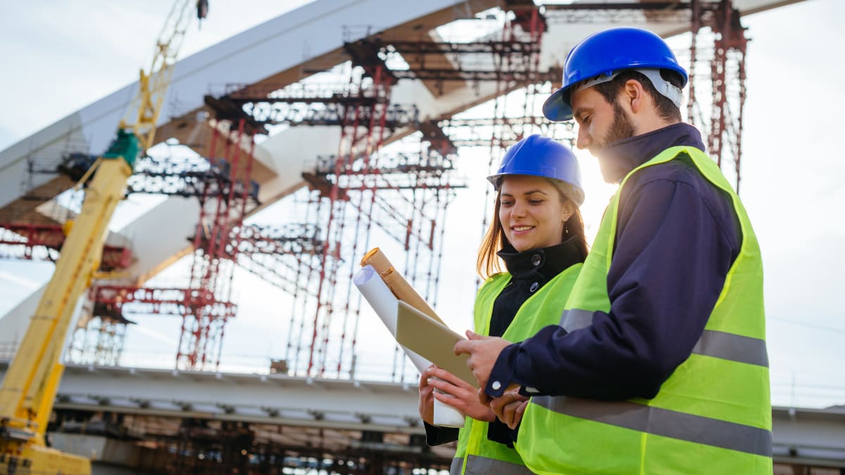 two civil engineers looking at plans for a project together