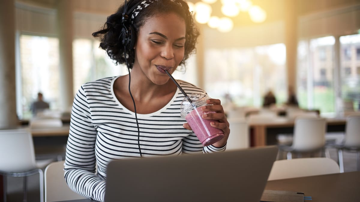 online student sitting in a cafeteria working on online coursework