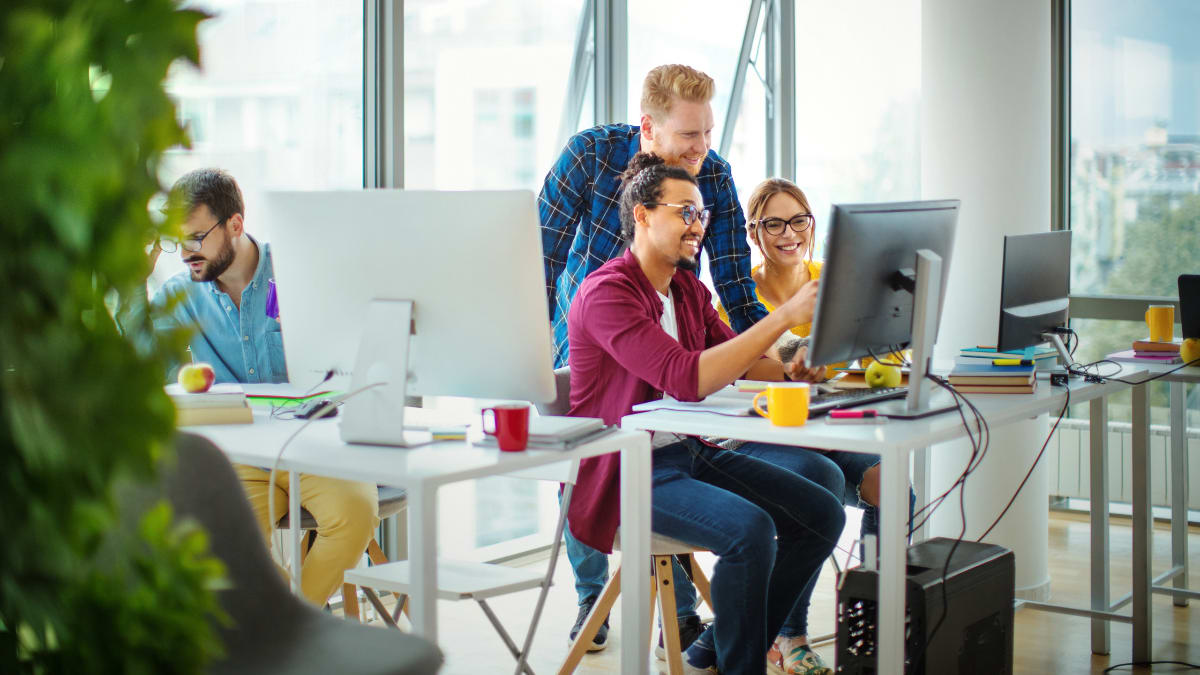 team of cyber security professionals looking at a computer together