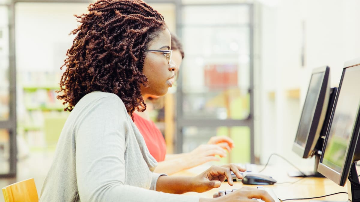 online cybersecurity student working on a desktop computer