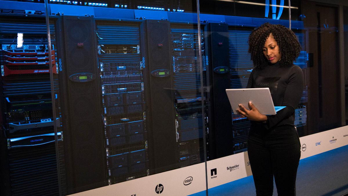 cybersecurity professional standing in front of a bank of servers