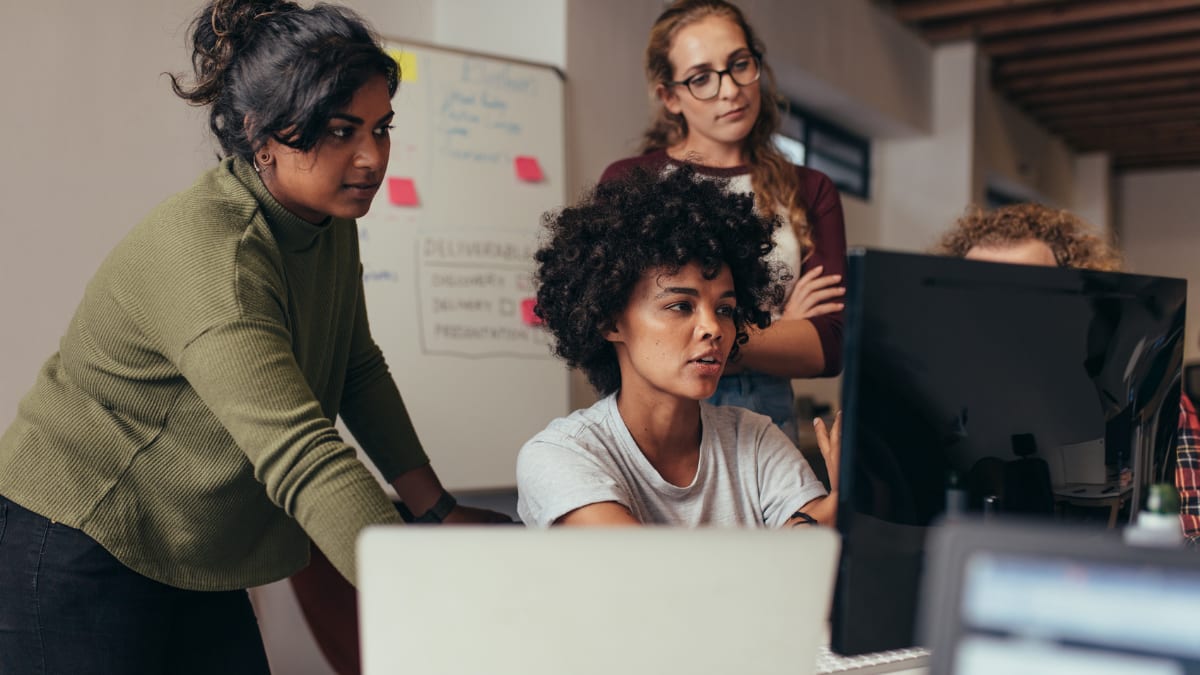 cybersecurity students working in front of a desktop computer