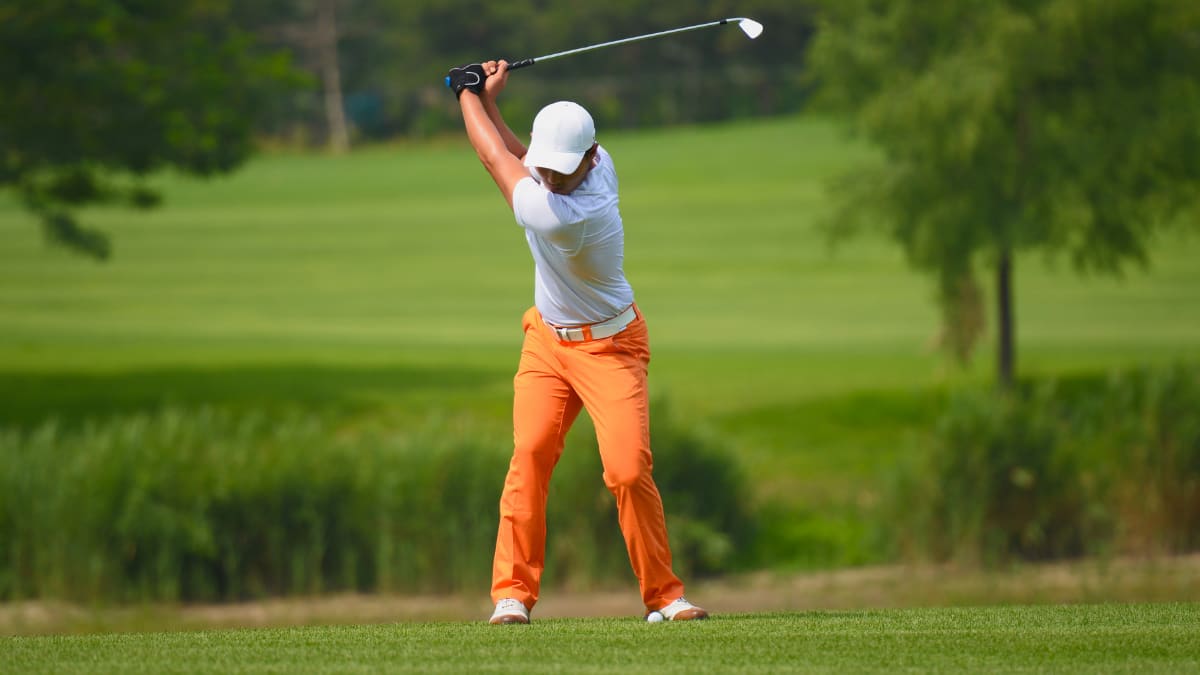 golfer taking a swing on a golf course
