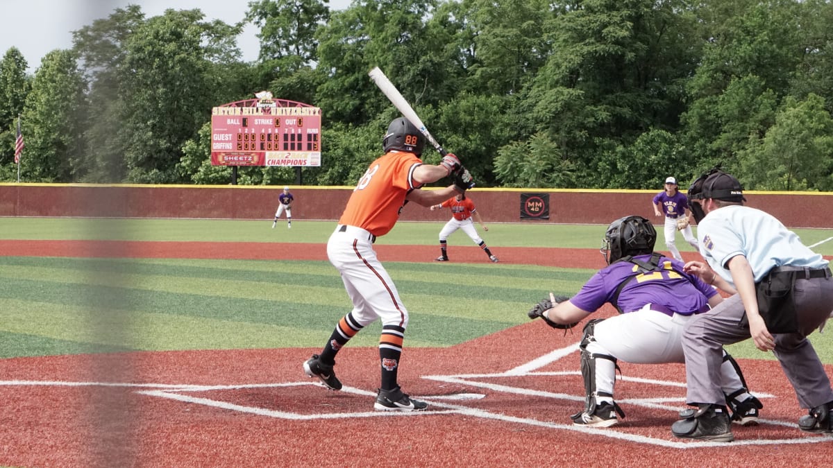 baseball player ready for a pitch, with a catcher and umpire behind him