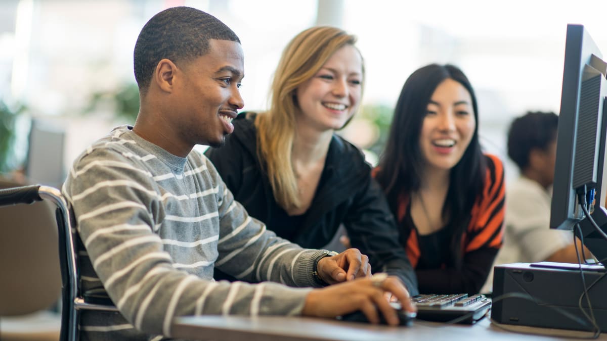 three students working together on an online college lesson