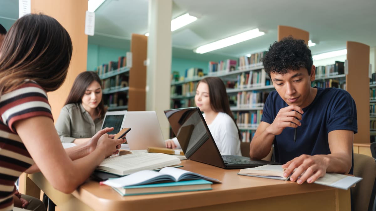 college students sitting together in a library studying
