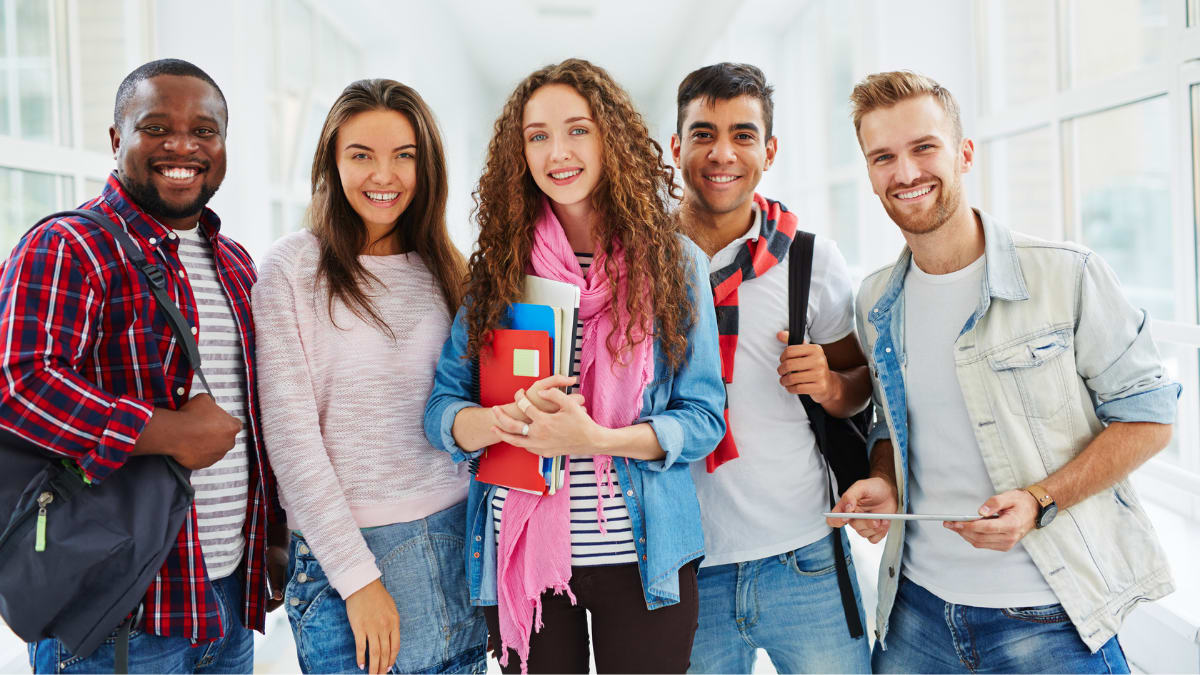 college students standing together in a building on a college campus