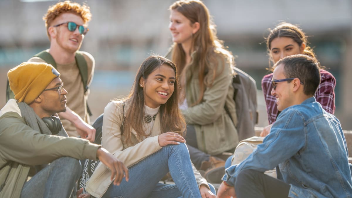 college students sitting outside on campus