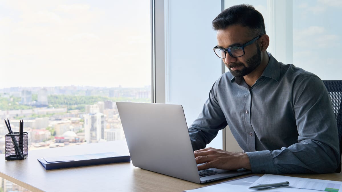 cybersecurity professional sitting at a desk in front of a laptop