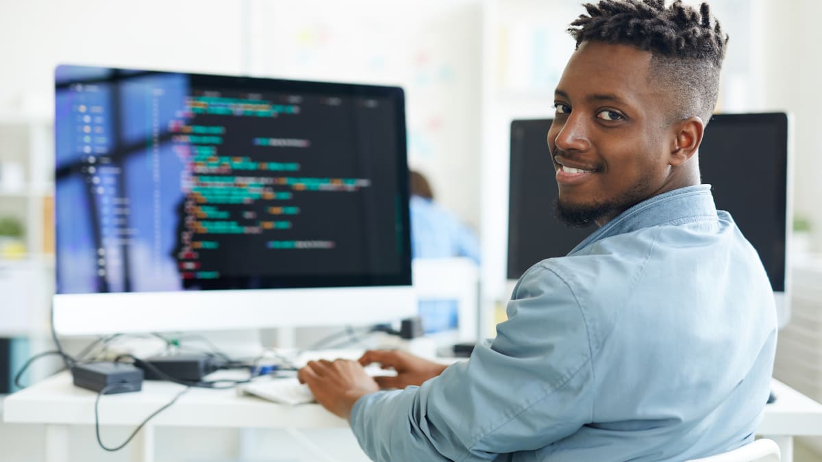 cybersecurity professional sitting at a desk in front of a laptop