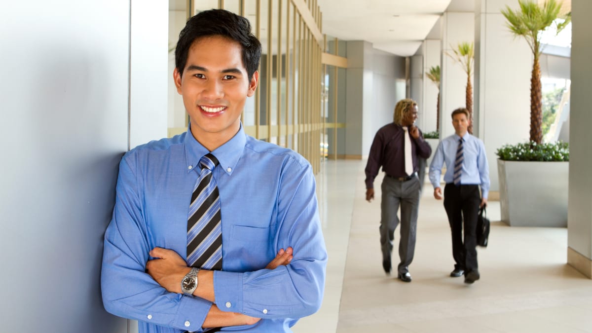 young business professional standing in a hallway in an office