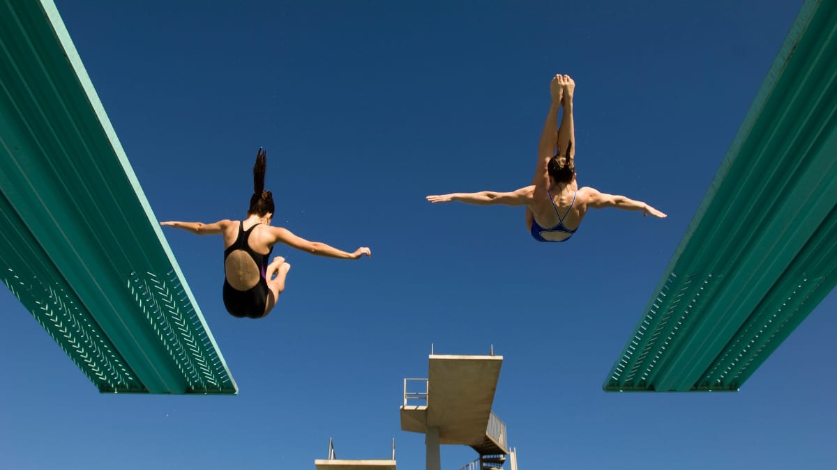 two divers diving off a diving board