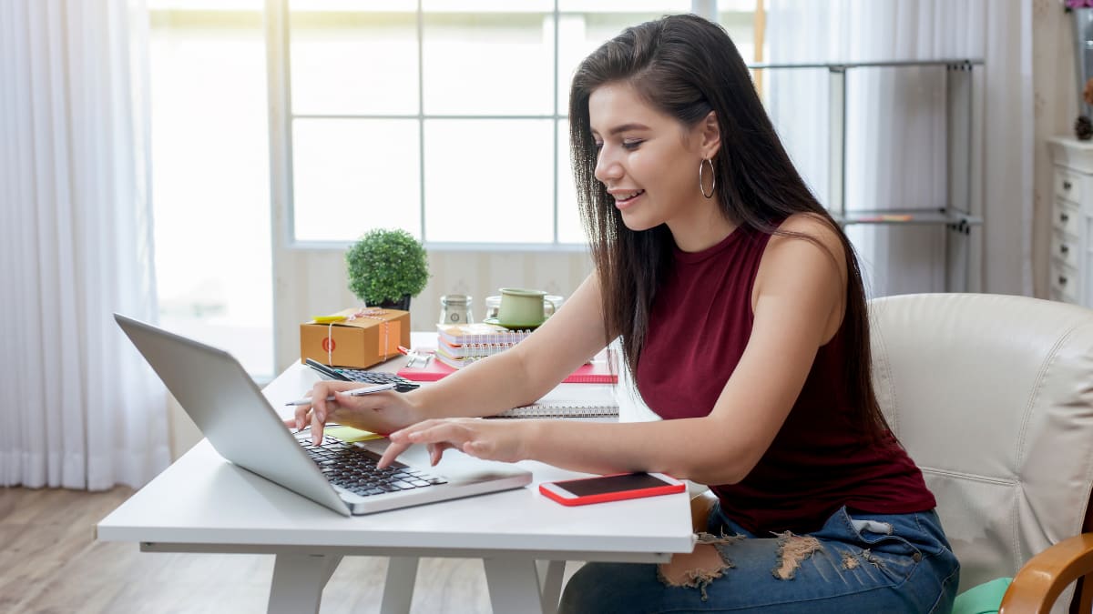 young business professional sitting at a desk typing on a laptop computer