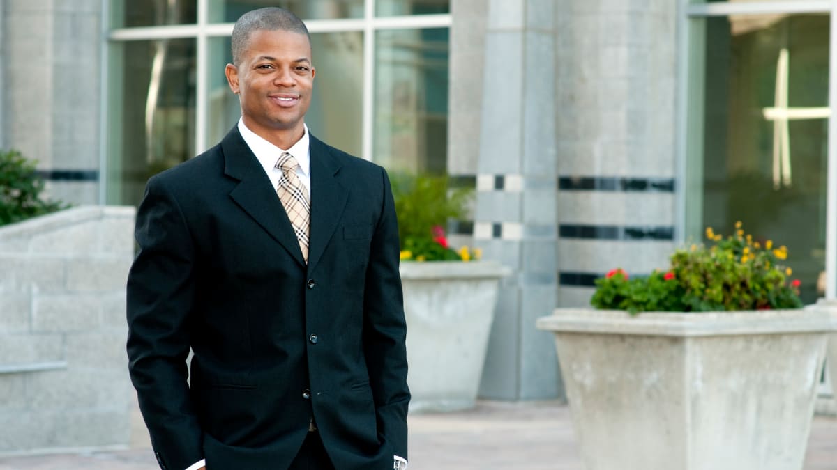 young business professional standing outside an office building