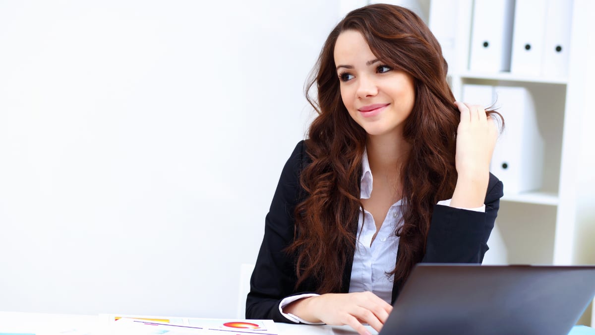 young business professional sitting at a desk in front of a laptop