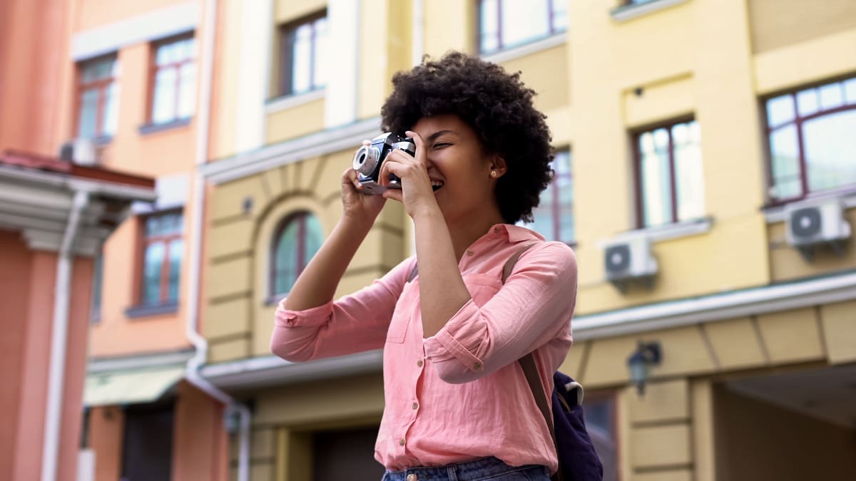 student standing outside taking pictures with a camera