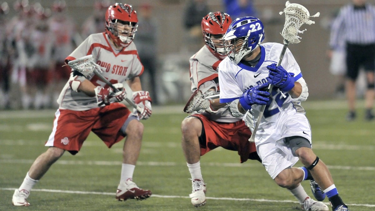 three lacrosse players in a game