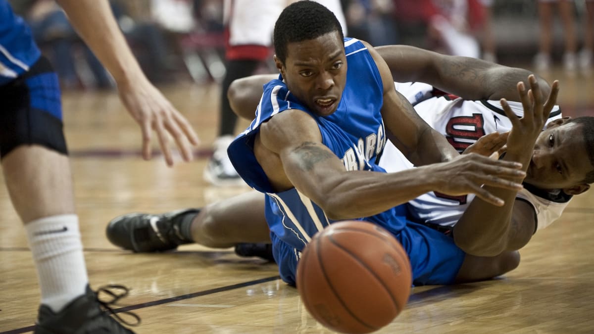 two basketball players battling over a basketball