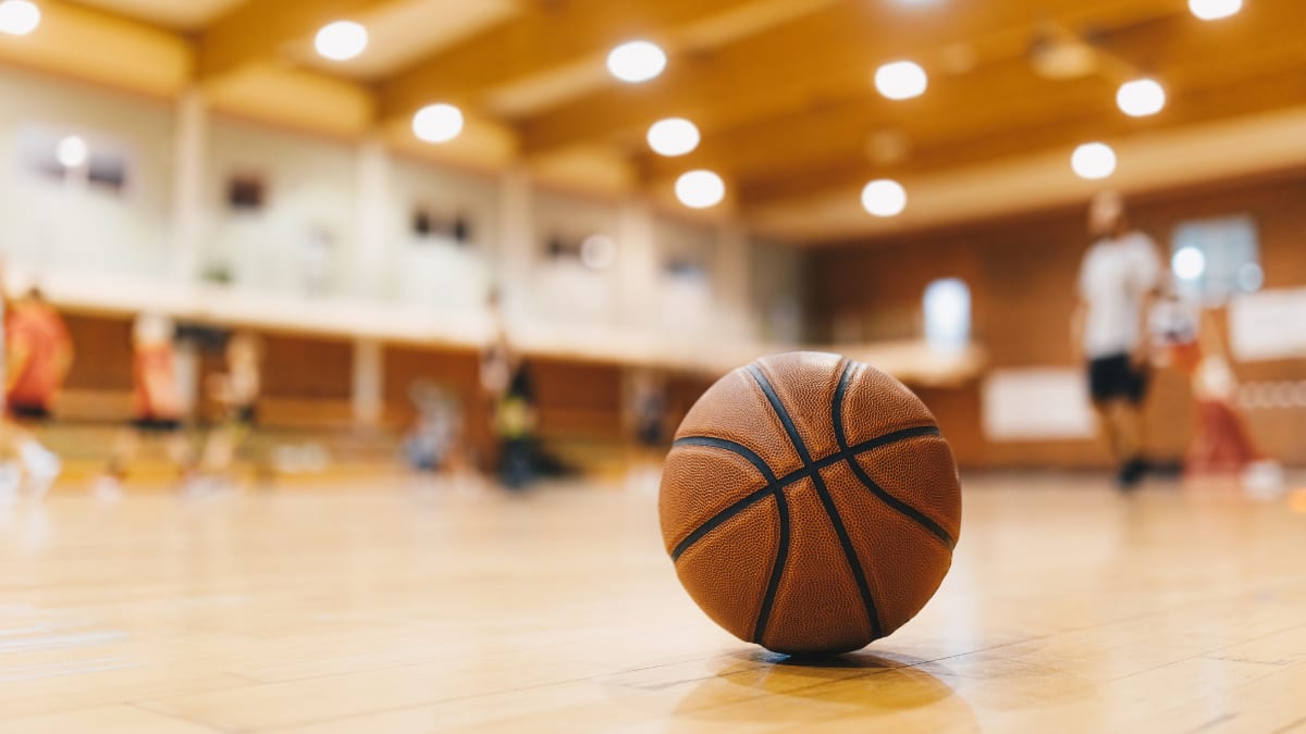 a basketball laying on the floor of a gym