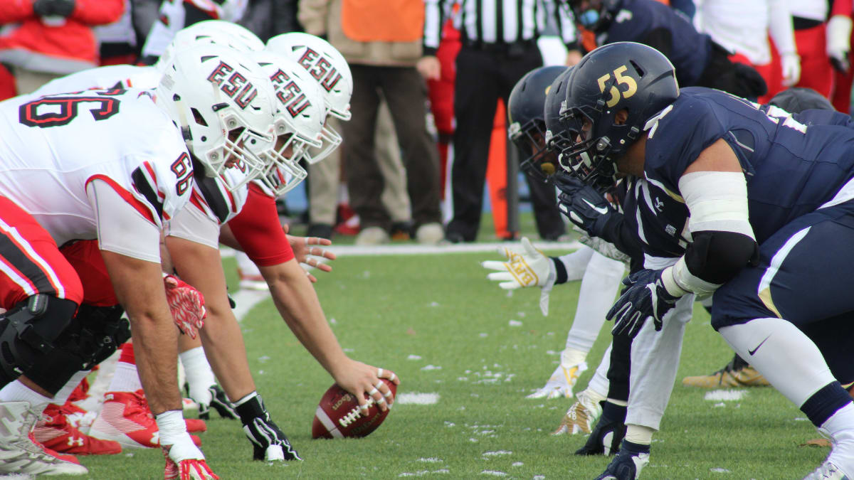 two opposing football teams getting ready for a play