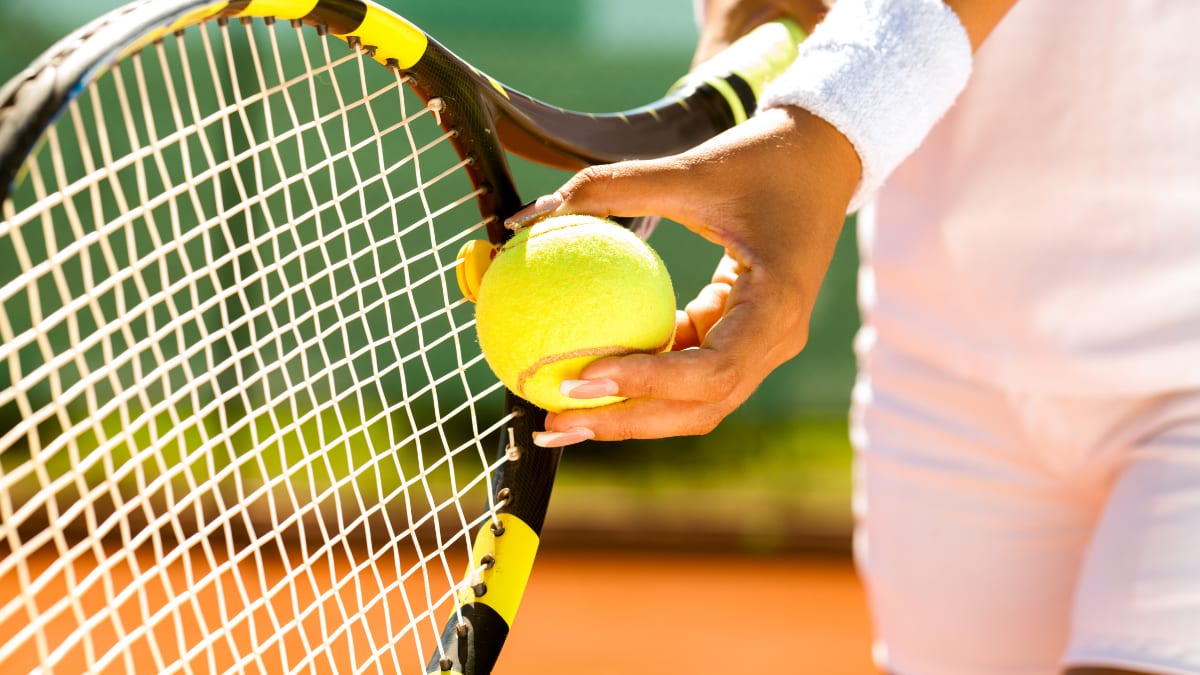 tennis player holding a tennis ball and a tennis racquet