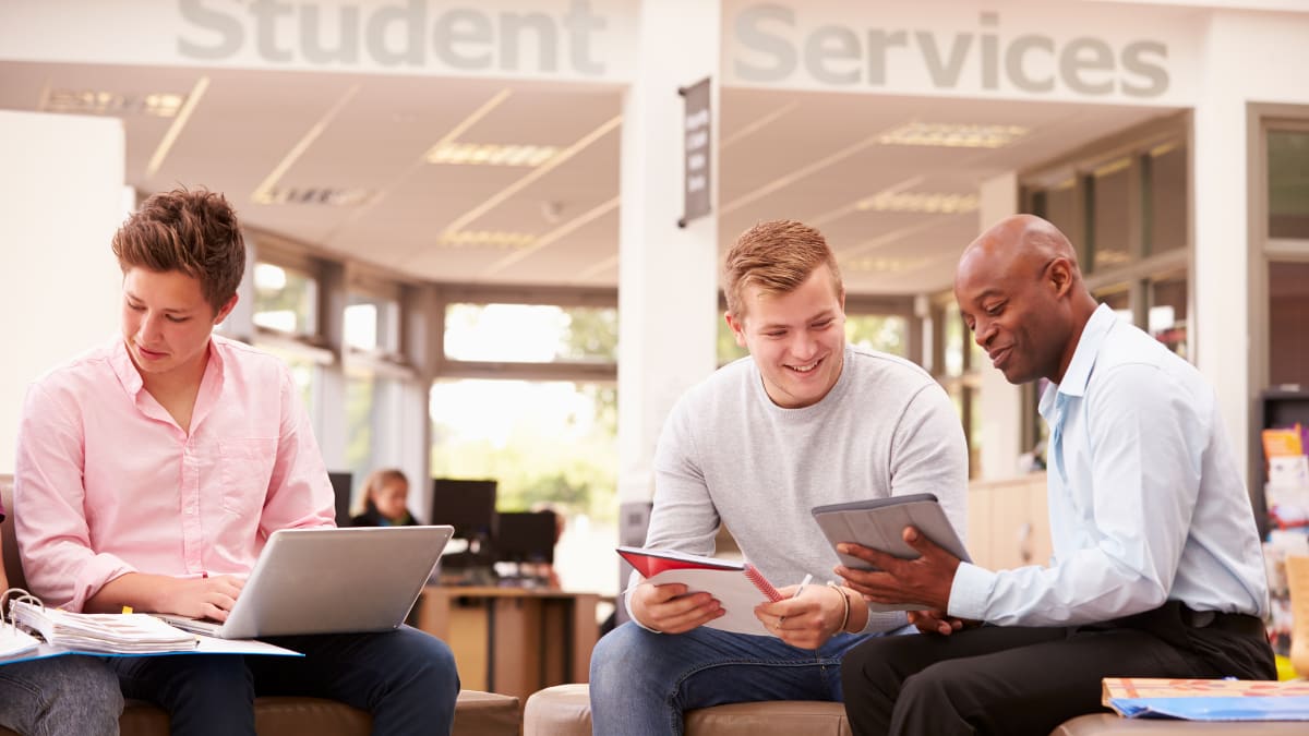 college student talking with a college counselor in front of student services