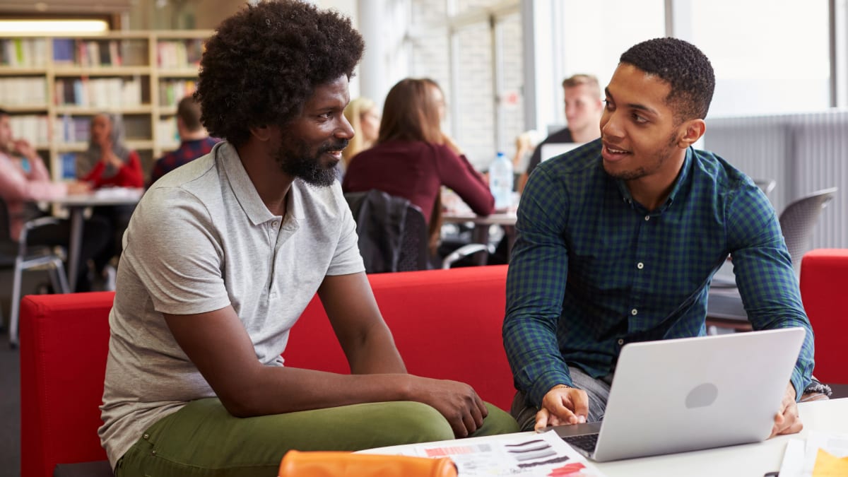 college student meeting with another student to discuss online programs