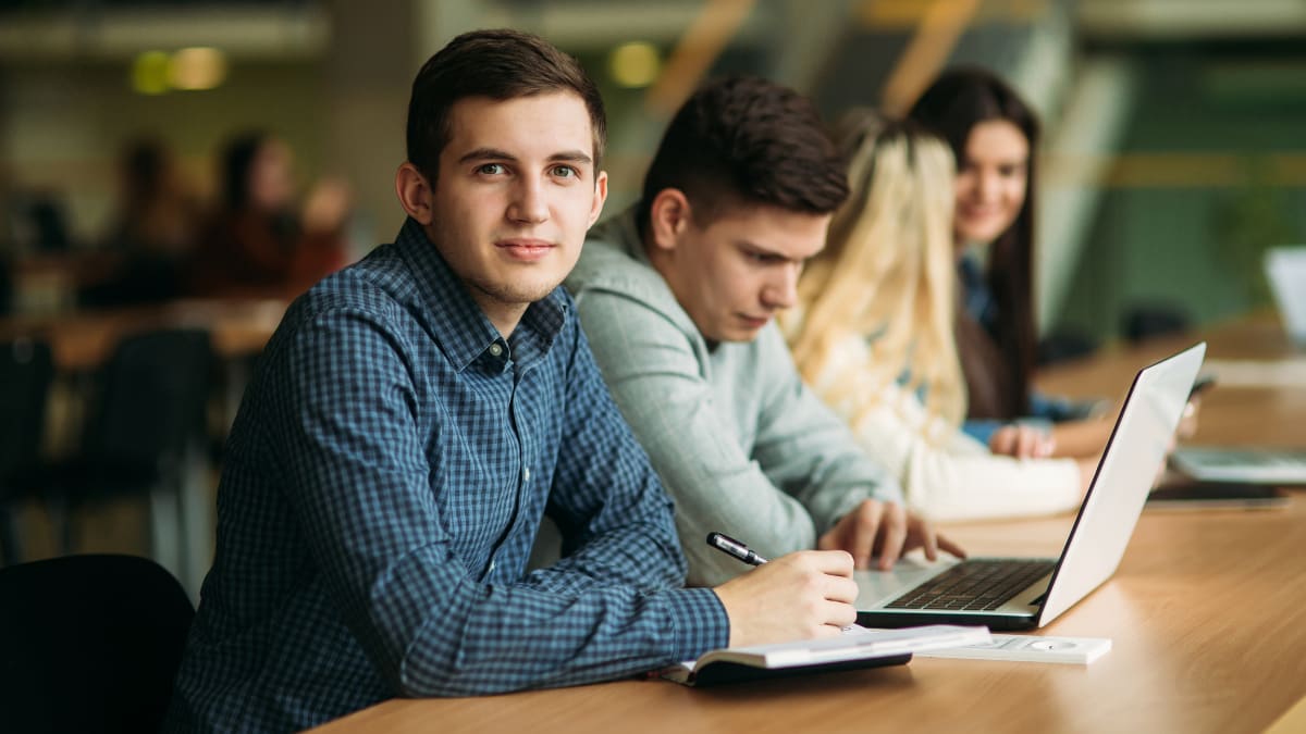 student sitting in a large lecture hall with a laptop