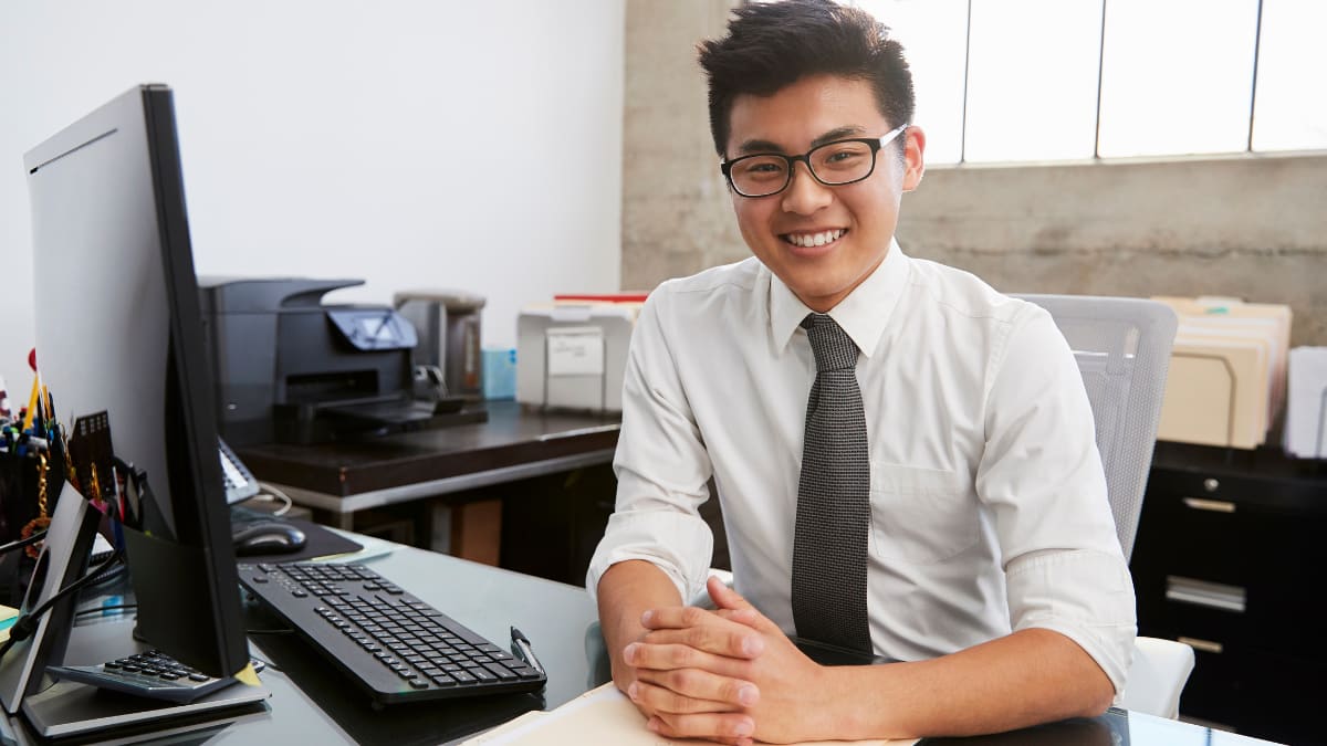 mba graduate sitting at a desk in front of a laptop