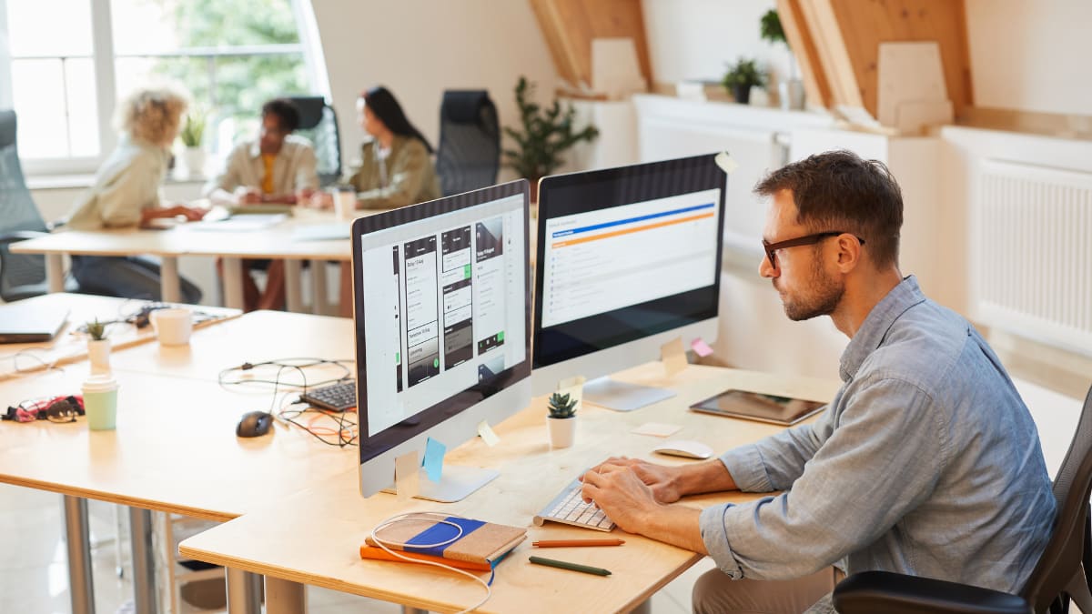 software programmer sitting at a desk in an office