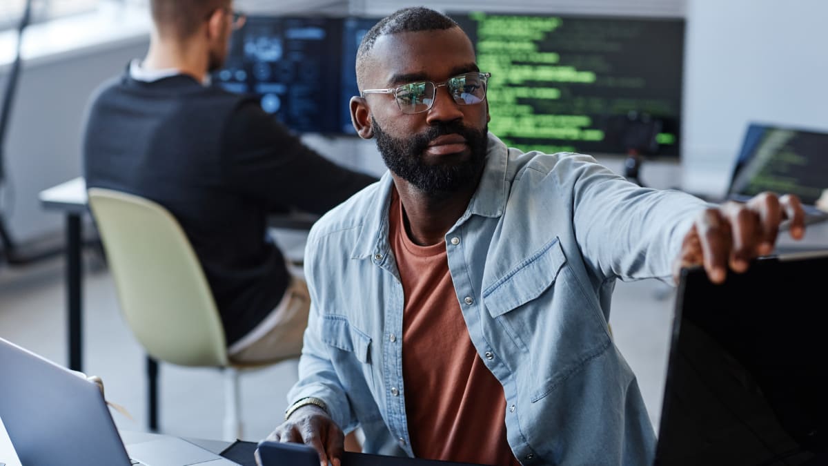 cyber security professional sitting at his desk in an office