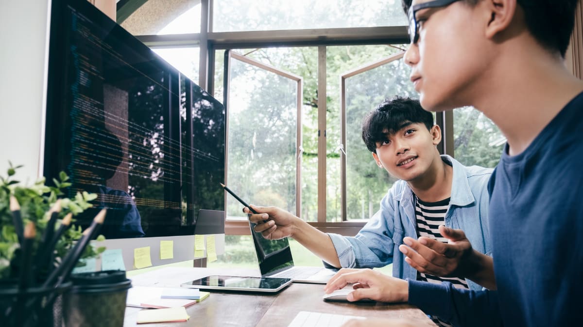 two cyber security students working on an online course