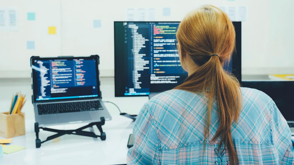 cybersecurity professional sitting at a desk in front of a computer monitor