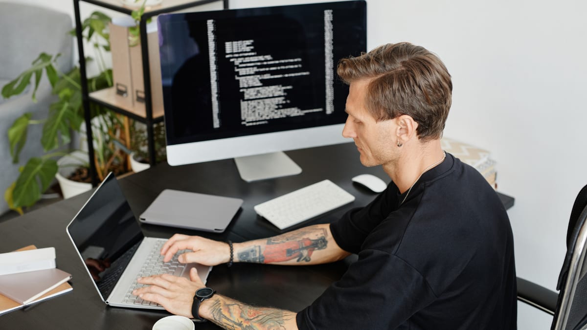 software programmer sitting at his desk working on code