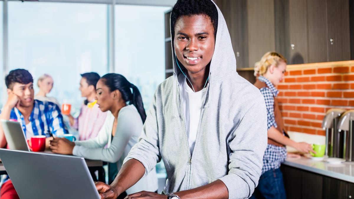 online college student working on a laptop in a cafeteria