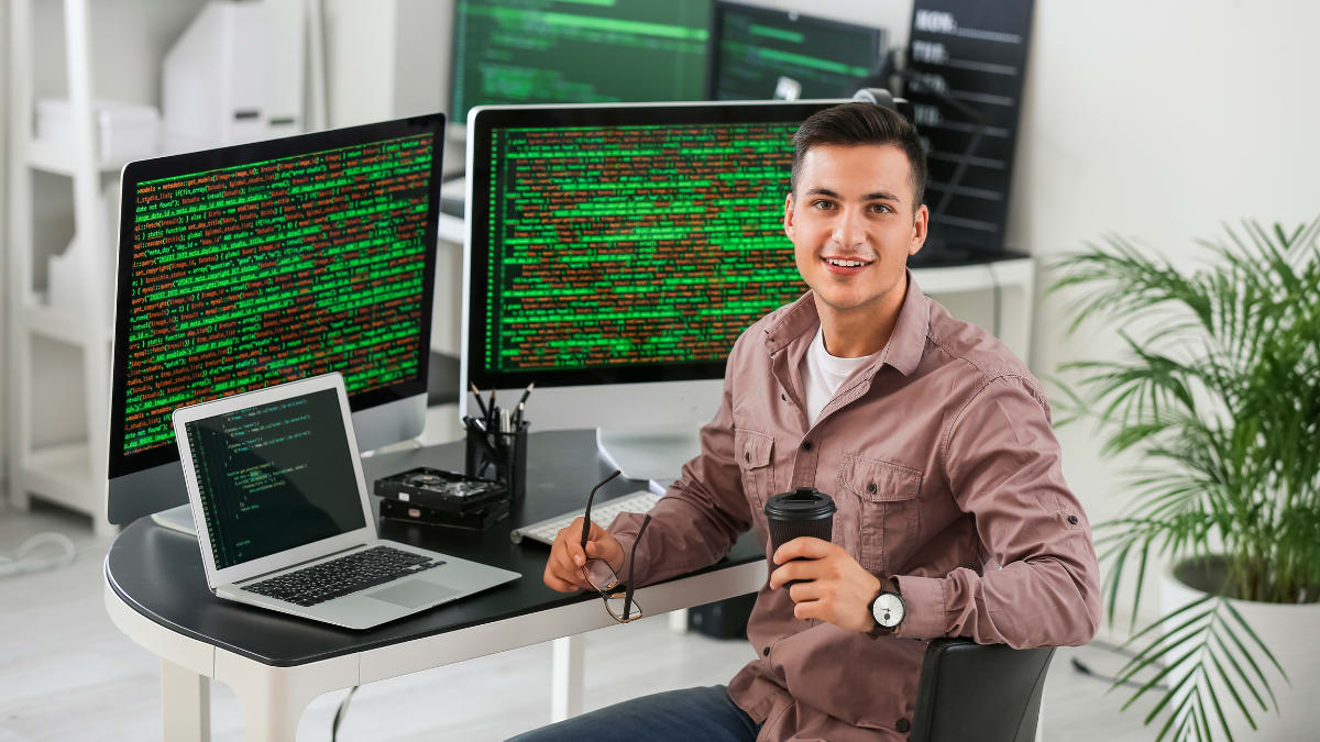 cyber security expert sitting in an office in front of several computers
