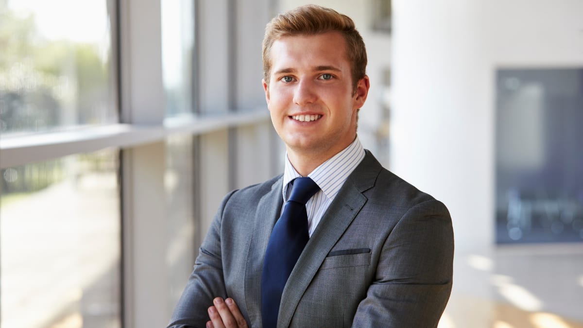 young business professional standing next to a window in an office