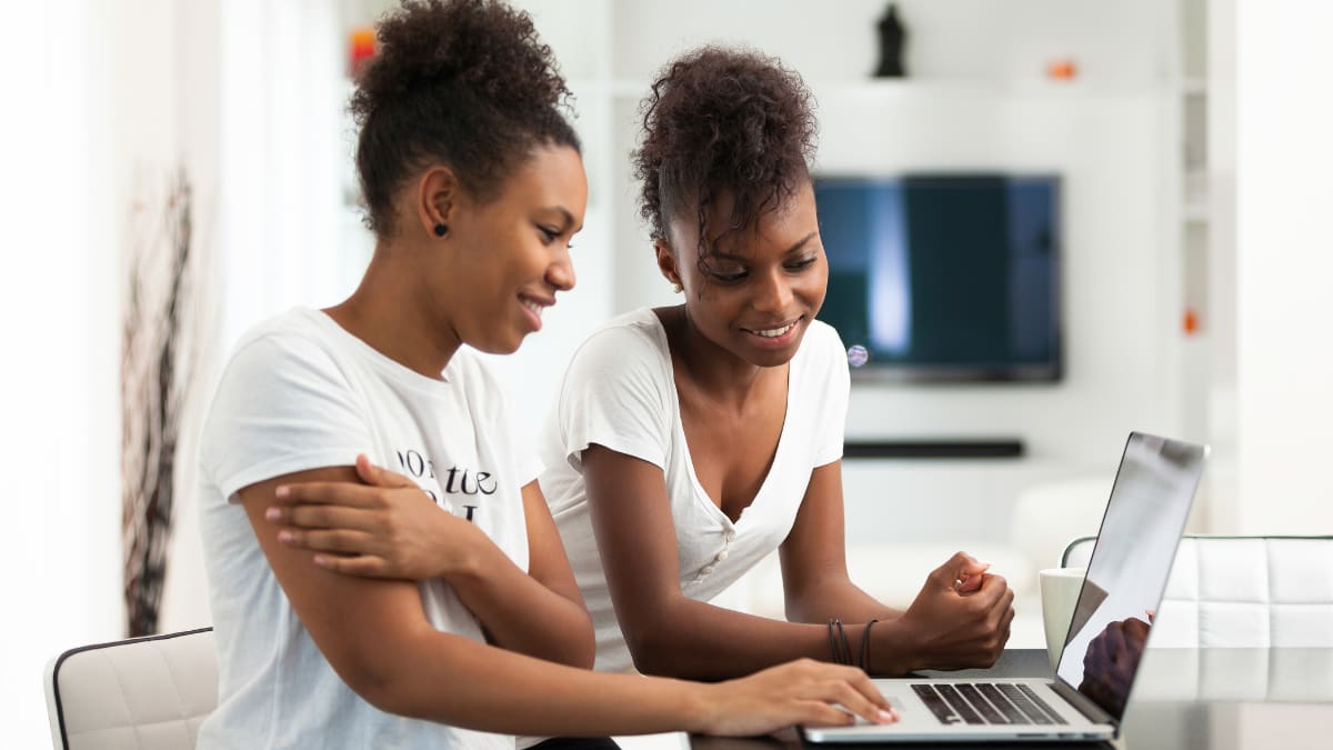 two online students sitting in front of a laptop
