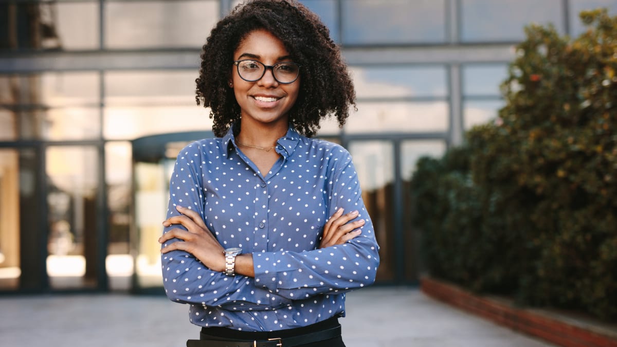 online graduate student standing outside an office building