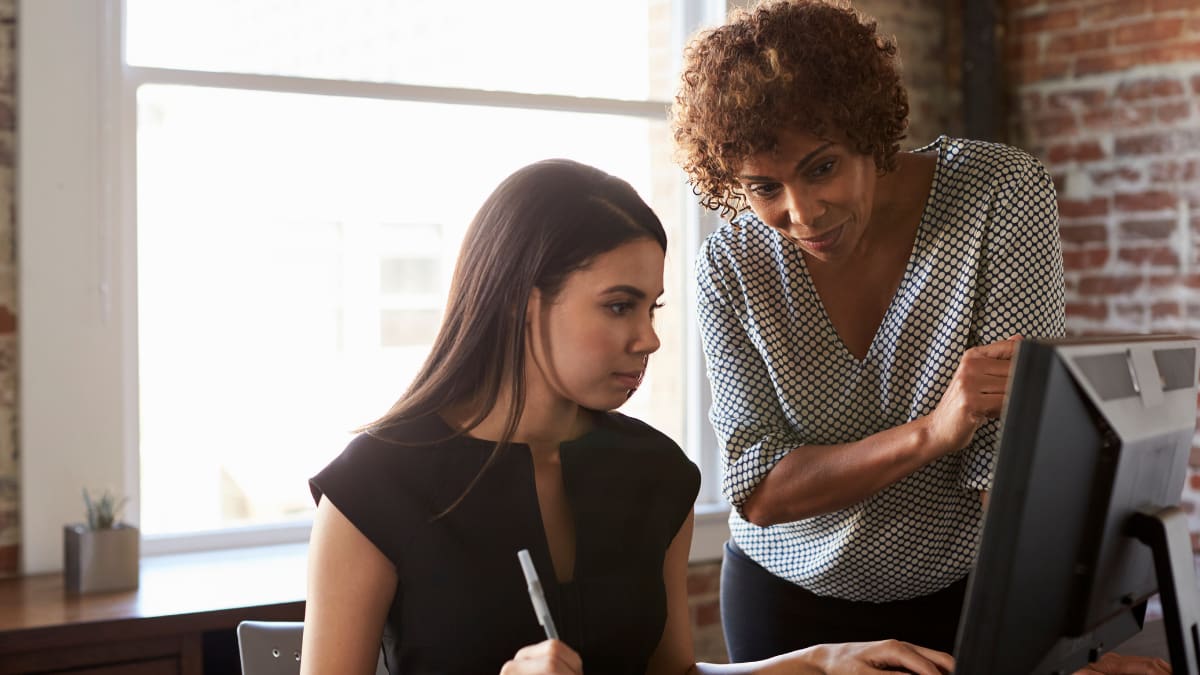 college mentor reviewing a project with a college student