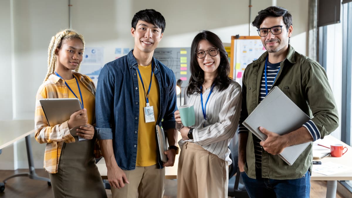 four graduate students standing together in a classroom