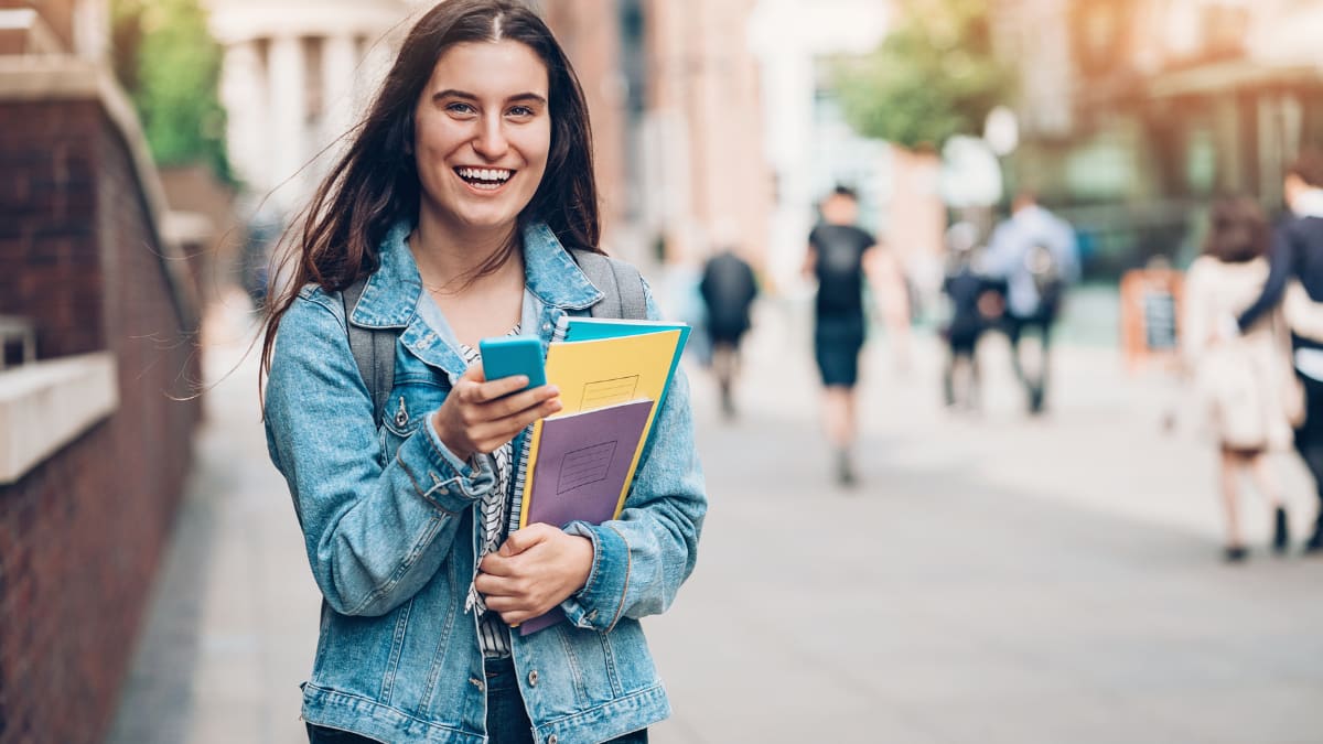 college student standing outside smiling at the camera