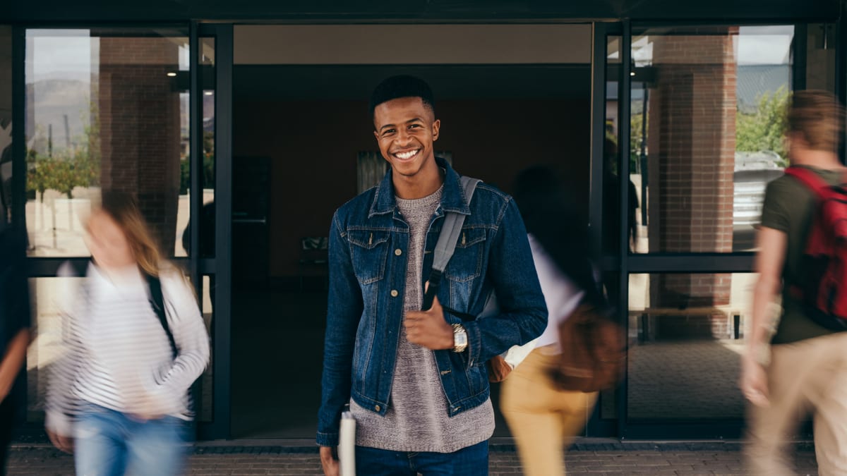 smiling college student standing outside a building