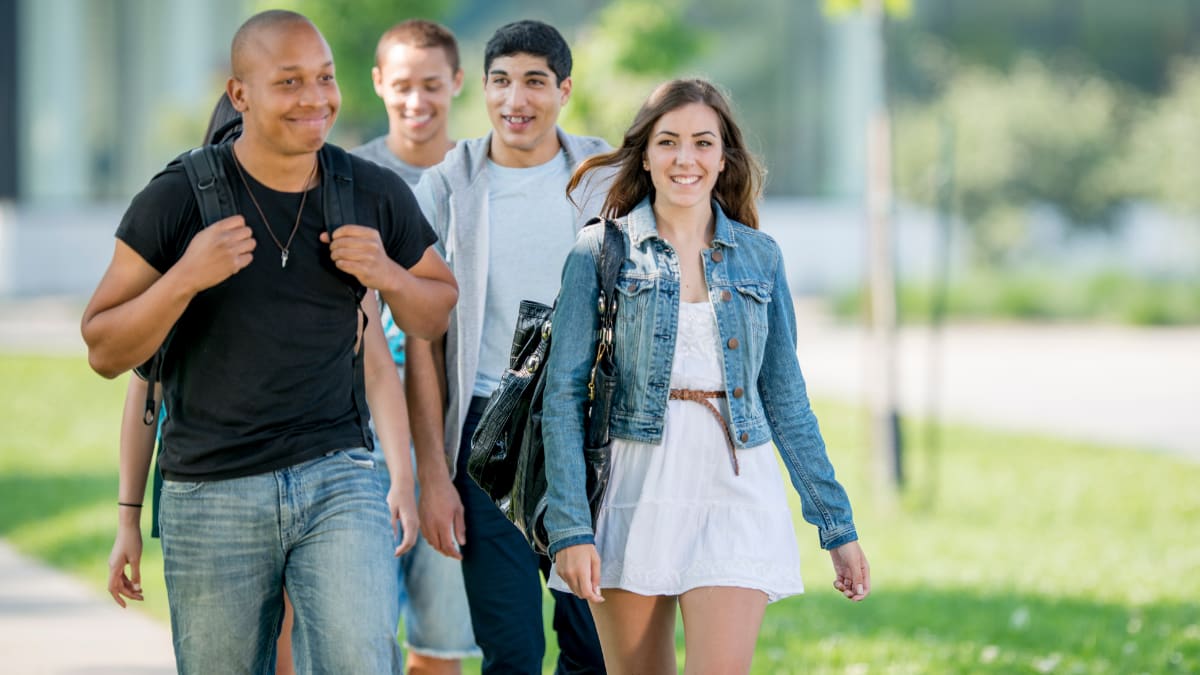 smiling college students walking outside on a college campus