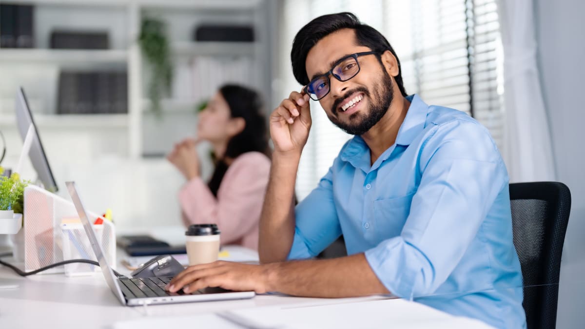 young business professional sitting at a desk in front of a computer